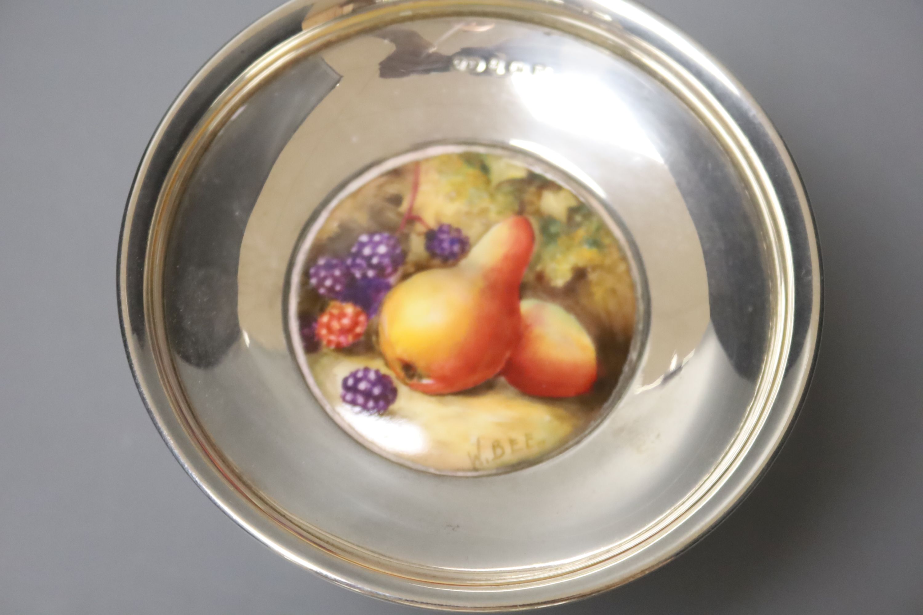 A George V silver pedestal nut dish, with inset Royal Worcester plaque, signed W. Bee, height 74mm, weighted.